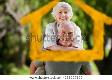 Man giving wife a piggyback against house outline in clouds