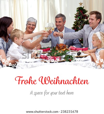 Family drinking a toast in a Christmas dinner against christmas greeting in german