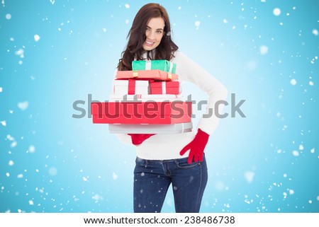 Pretty brunette posing and holding pile of gifts against blue vignette