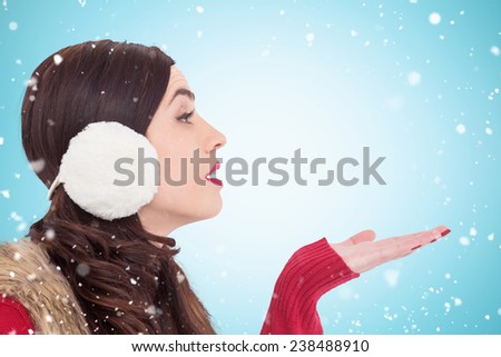 Brunette in winter clothes with hand out against blue vignette