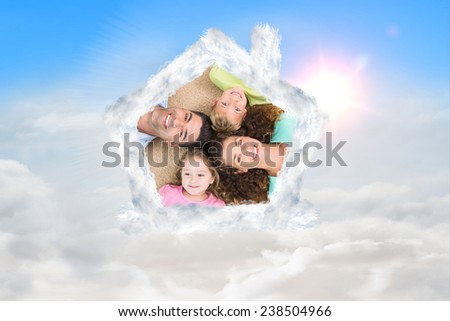 Happy family lying on the rug in a circle against blue sky with white clouds
