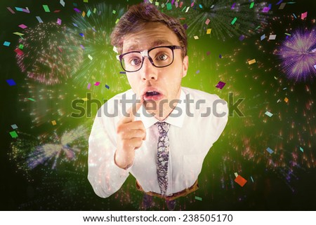 Young geeky businessman looking at camera against colourful fireworks exploding on black background