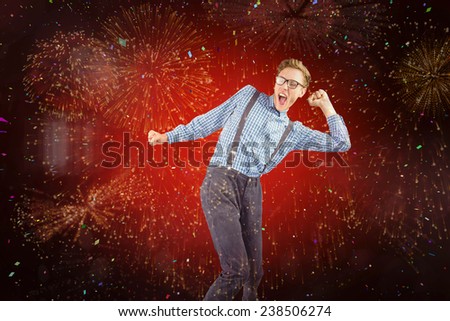 Geeky hipster dancing to vinyl against colourful fireworks exploding on black background