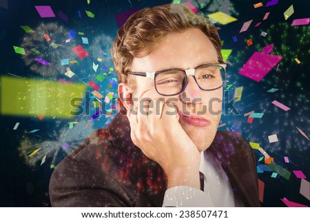 Young geeky businessman looking bored against colourful fireworks exploding on black background