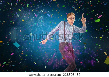 Geeky hipster dancing to vinyl against colourful fireworks exploding on black background