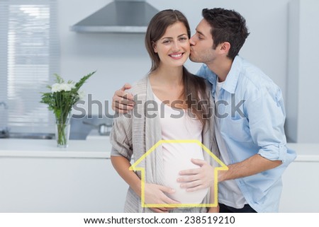 Man kissing his pregnant wife against house outline