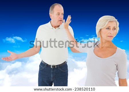 Older couple having an argument against bright blue sky over clouds