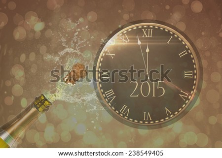 Clock counting down to midnight against champagne popping