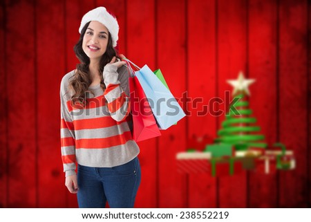 Beauty brunette posing with shopping bags against blurred christmas background