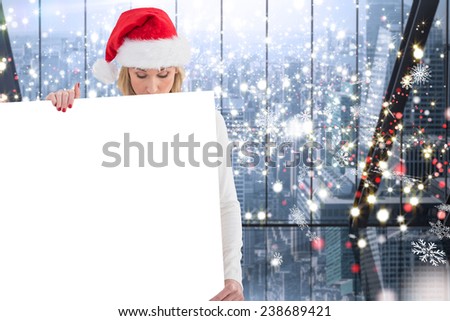 Festive blonde showing poster against glittering lights in room