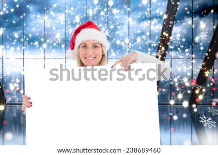 Festive blonde showing white poster against glittering lights in room