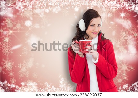 Woman in winter clothes holding a mug against white snowflake design on red