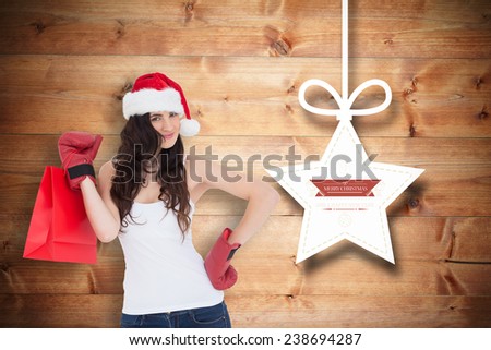 Beauty brunette in boxing gloves with shopping bag against christmas decorations over wood