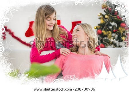 Festive mother and daughter on the couch against frost frame