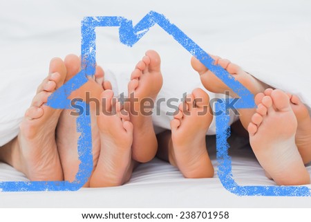 Feet of family sticking out from the quilt against house outline