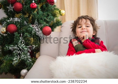 Festive little boy smiling at camera against hanging stars