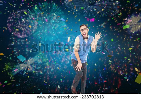 Geeky hipster dancing like a fool against colourful fireworks exploding on black background