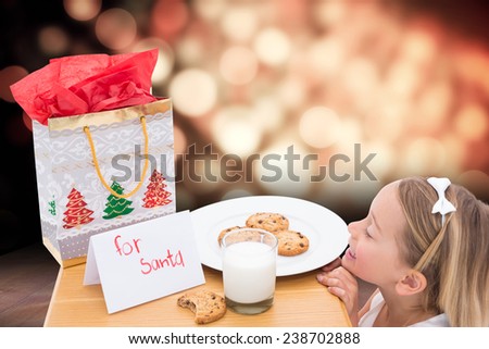 Milk and cookies left out for santa against light design over floor boards