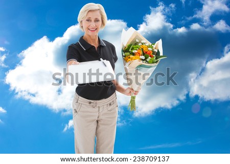 Happy flower delivery woman looking for signature against cloudy sky