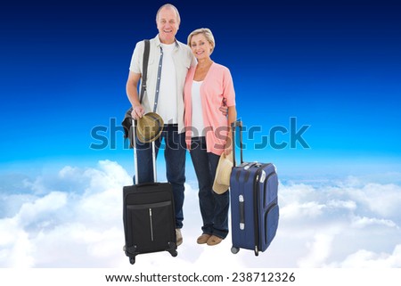 Smiling older couple going on their holidays against blue sky over clouds