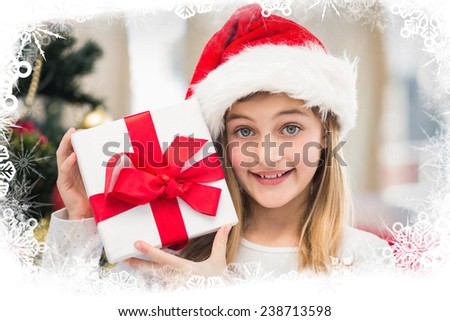 Festive little girl holding a gift against frost frame