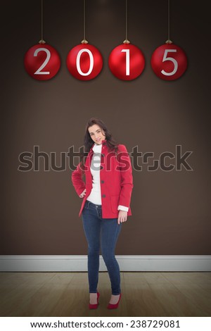 Beauty brunette posing in red coat and heels against room with wooden floor