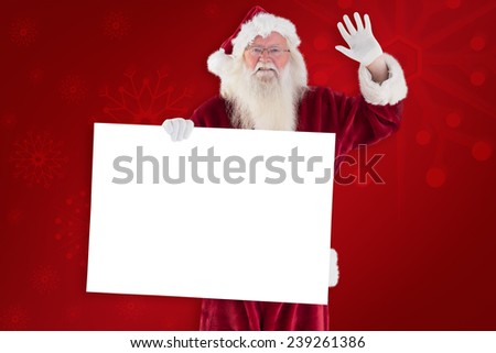Santa holds a sign and is waving against red background