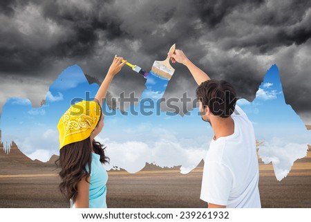 Composite image of happy young couple painting the sky from dark to light