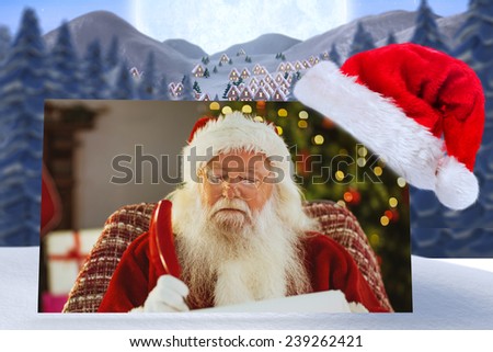 Santa claus writing his list with a quill against cute christmas village under huge full moon