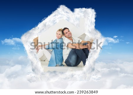 Smiling couple with boxes in a new house against bright blue sky over clouds