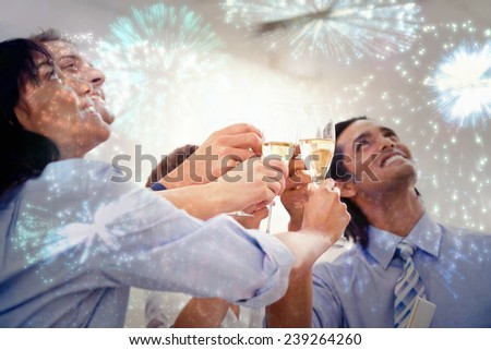 Cheerful business team toasting with Champagne against colourful fireworks exploding on black background