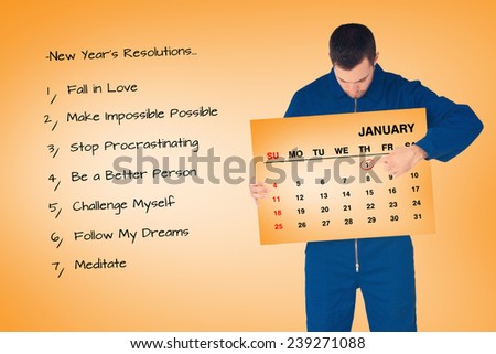 Young mechanic in boiler suit pointing on calendar in his hands against orange card