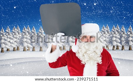 Happy santa claus holding speech bubble against snowy landscape with fir trees