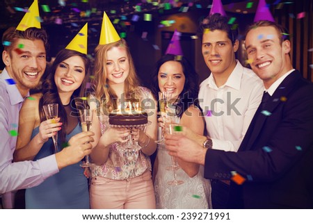 Attractive friends celebrating a birthday against flying colours