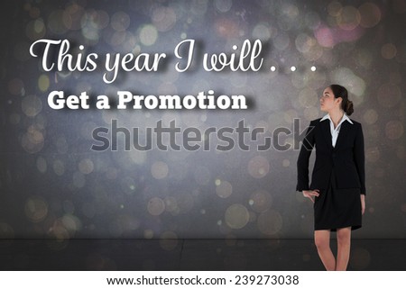 Young businesswoman standing with hand on hip against dark abstract light spot design