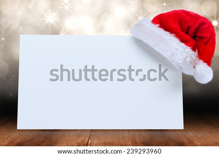 Santa hat on poster against shimmering light design over boards