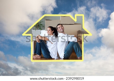 Bright couple with unpacking boxes moving to a new house against blue sky with white clouds