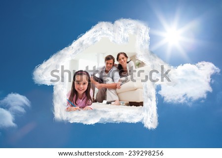 Cute girl drawing with her parents in the background against bright blue sky with clouds