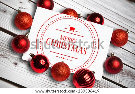 Banner and logo saying merry christmas against digitally generated grey wooden planks