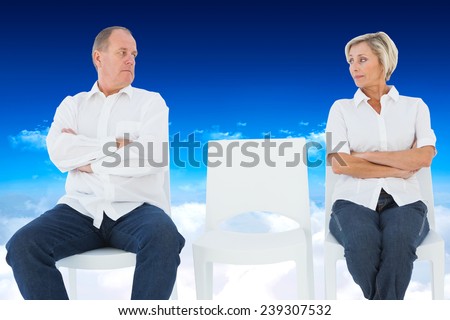 Upset couple not talking to each other after fight against bright blue sky over clouds