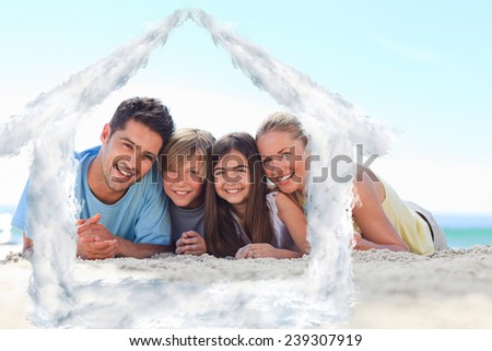 Children with their parents on the beach against house outline in clouds