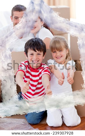 Family moving house with boxes and thumbs up against house outline in clouds