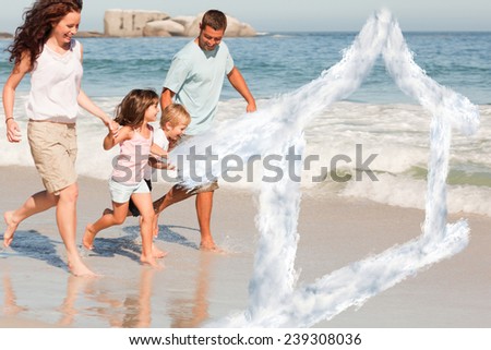 Family running on the beach against house outline in clouds