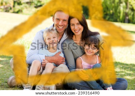 House outline in clouds against family sitting in the park