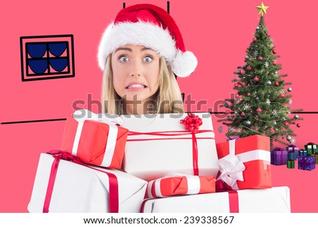 Festive blonde holding pile of gifts against pink