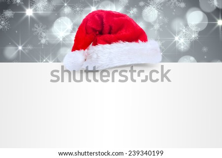 Santa hat on poster against shimmering light design on grey