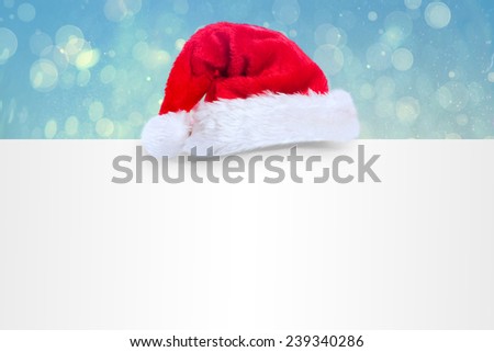 Santa hat on poster against blue abstract light spot design
