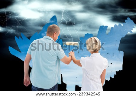 Composite image of happy older couple painting the sky from dark to light