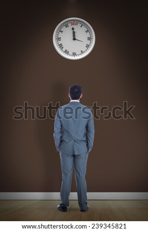 Businessman standing against room with wooden floor