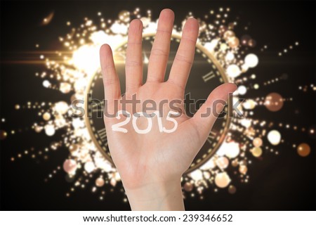 Hand with fingers spread out against black and gold new year message